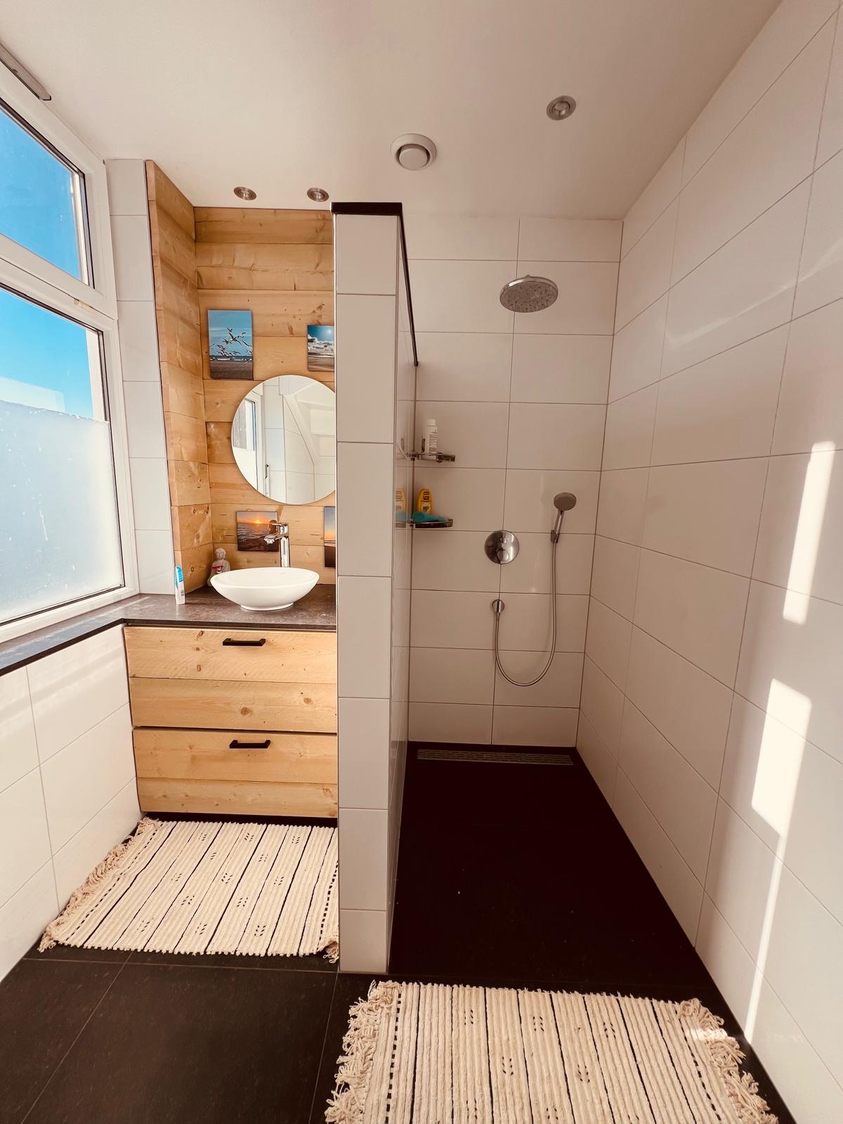 Badkamer met inloopdouche en houten meubel