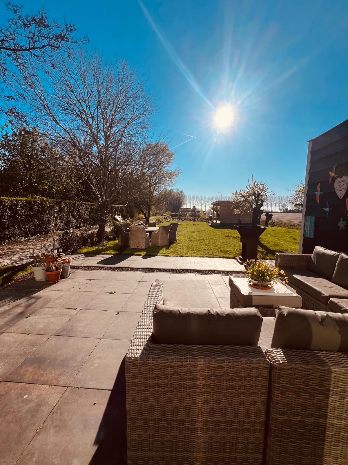 Zonnig terras met loungeset in de tuin